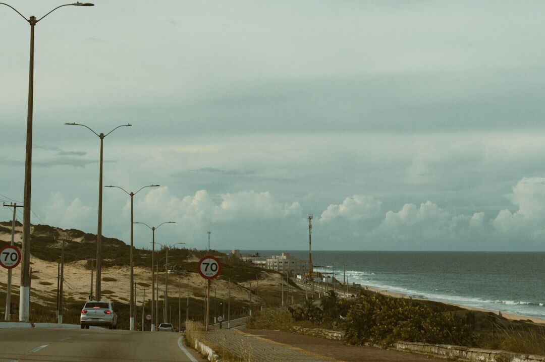 Vintage sports car driving along a coastal road in Punta del Este at sunset